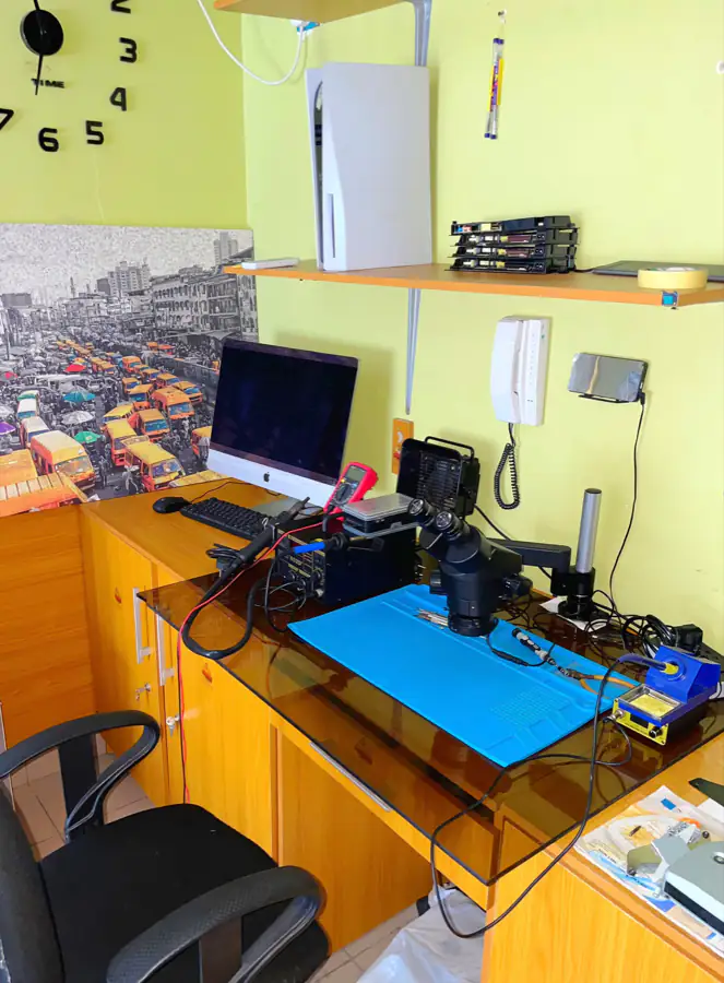 Repair bench with a stereo microscope, hot-air rework station, soldering iron and anti-static mat.