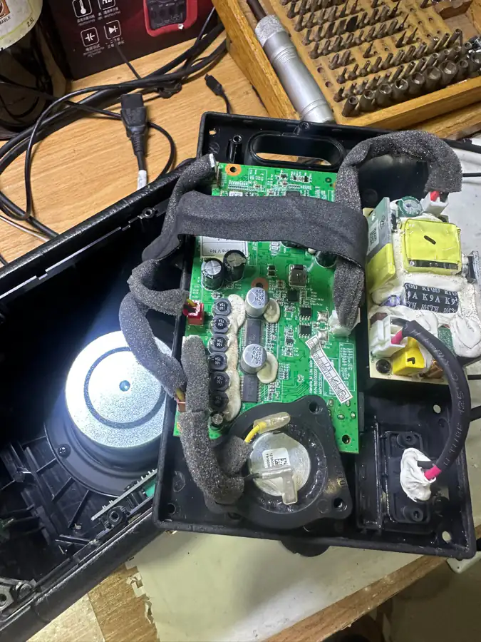 A Marshall Bluetooth speaker opened on the bench with its amplifier board and driver exposed.