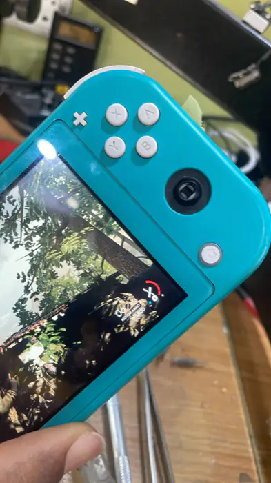 Nintendo Switch Lite with the right analogue stick missing, showing the bare stick mechanism.